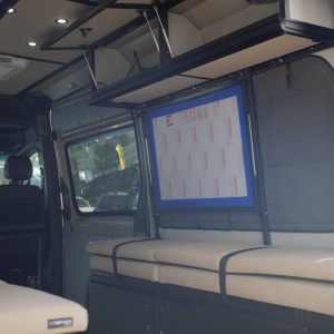 Van conversion overhead cabinet with lift-assisted doors inside a Mercedes Sprinter van build