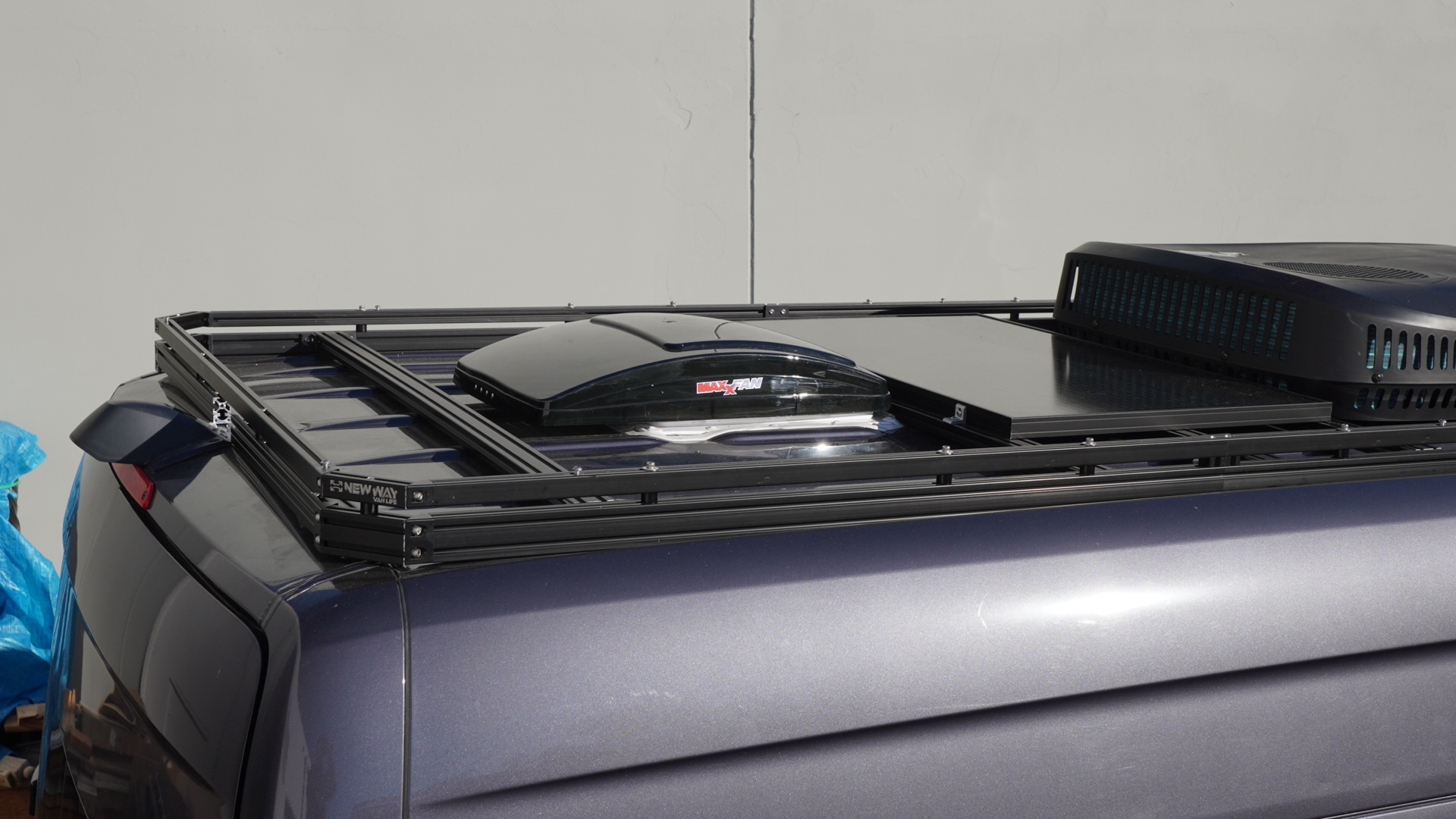 New Way Van Life aluminum roof rack installed on a 2022-2026 Mercedes Sprinter van with a MaxxAir MaxxFan roof vent and rooftop AC unit mounted on the platform