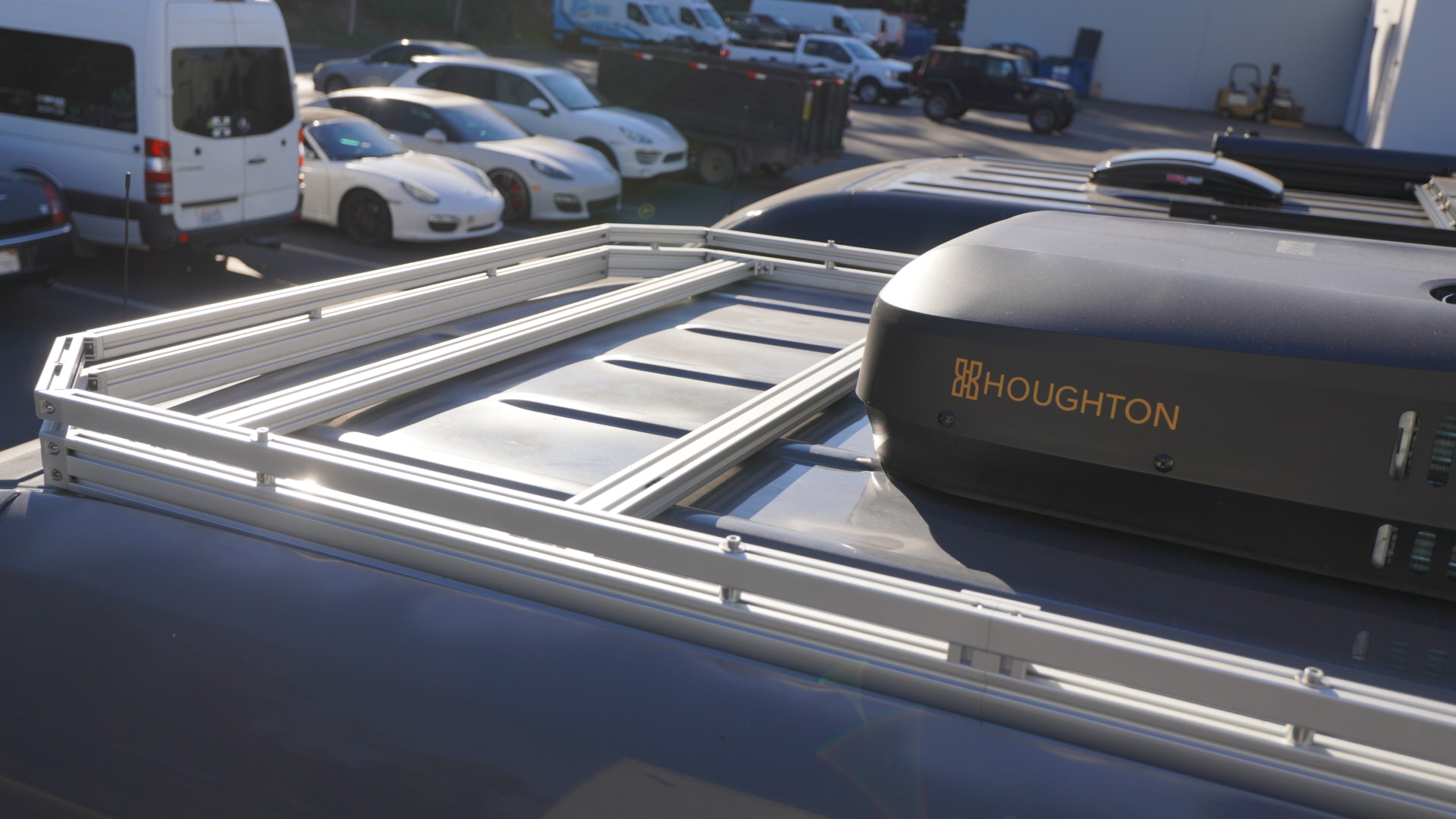 Silver aluminum roof rack installed on a 2025 Mercedes Sprinter van with a Houghton rooftop AC unit mounted on the platform shown from a close overhead angle