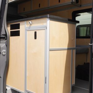 Full height interior view of New Way Van Life Mercedes Sprinter conversion through open sliding door showing custom birch plywood galley module, overhead storage cabinets, recessed LED ceiling lights, and Houghton rooftop air conditioning unit