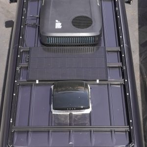 Aerial top-down view of Mercedes Sprinter van black roof rack fully loaded with solar panels Houghton rooftop AC unit and MaxxAir MaxxFan roof vent by New Way Van Life