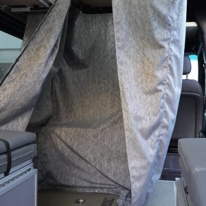 Custom Sunbrella water-resistant shower curtain fully deployed as a shower enclosure inside a Mercedes Sprinter van conversion showing the shower pan drain, ceiling mount hardware, and full interior context by New Way Van Life