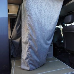 Custom Sunbrella water-resistant shower curtain hanging from ceiling track hardware in the sliding door opening of a Mercedes Sprinter van conversion by New Way Van Life