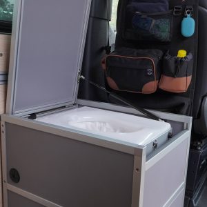 New Way Van Life Wrappon toilet cabinet with top lid fully open showing the Wrappon toilet unit inside a Mercedes Sprinter van conversion from a side angle
